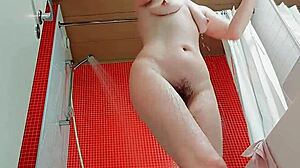Voyeuristic view of a mature woman's hairy pussy and wet body in the bathroom