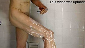 一个同性恋裸体在淋浴间展示他的未割包皮阴茎